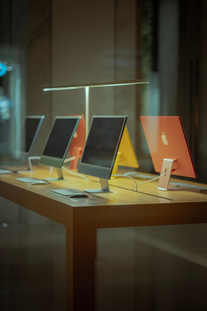The Art of Drawing Readers In: Your attractive post title goes here Vibrant desktop computers showcased on a wooden table in modern retail environment.