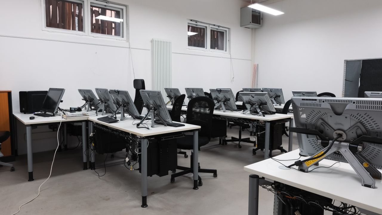 Crafting Captivating Headlines: Your awesome post title goes here An empty computer lab featuring multiple vacant workstations with modern monitors.